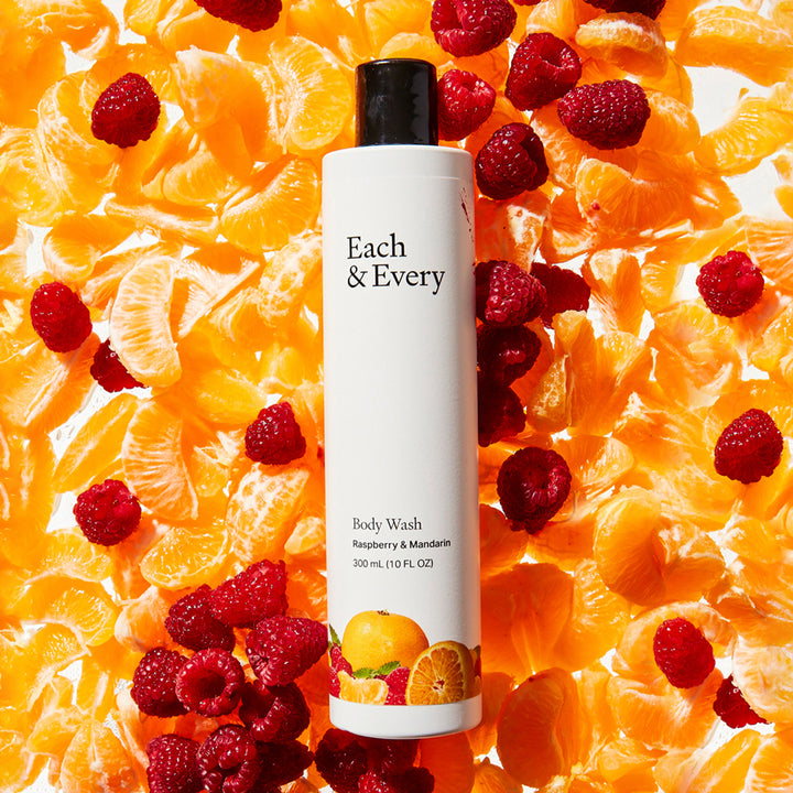 product Raspberry & Mandarin Body Wash on a bed of raspberries and mandarin orange sections