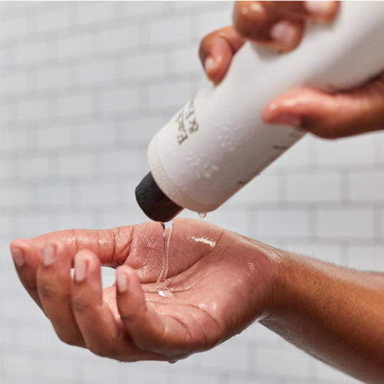 product woman pouring body wash into her hand in the shower