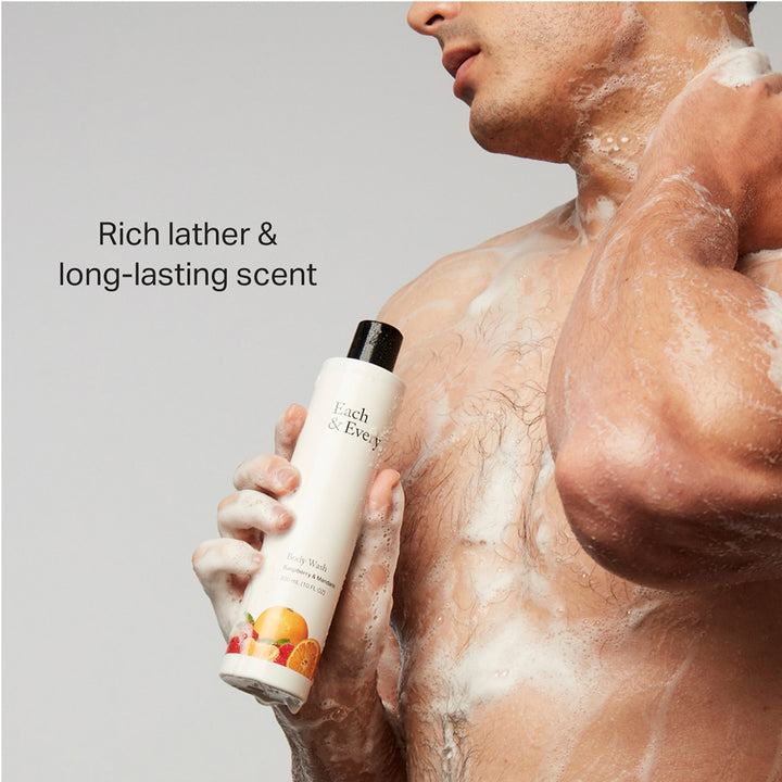 product man in the shower holding Raspberry & Mandarin body wash. Caption: Rich later & long-lasting scent