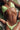 woman in a light green bikini laying on a towel with sand on her skin soaking up the sun