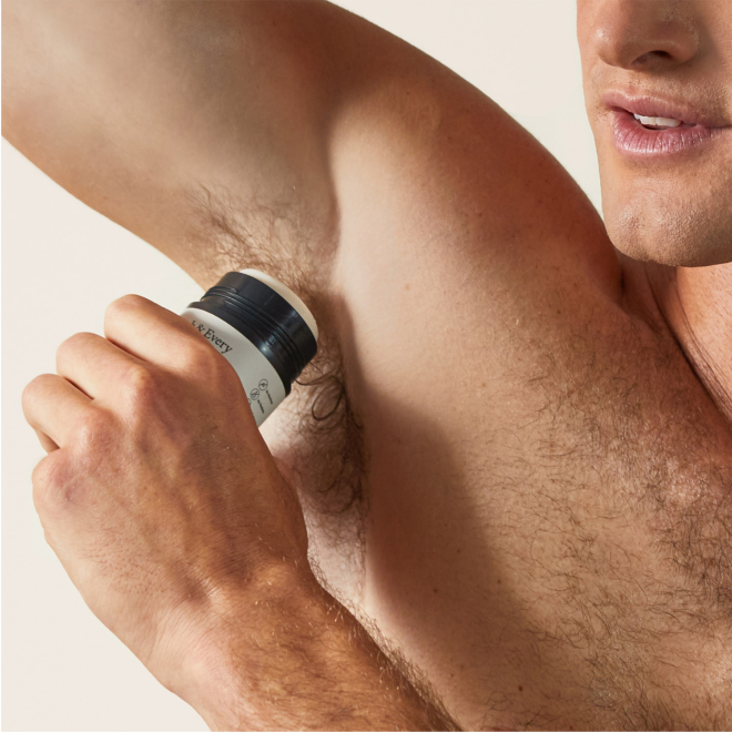 man applying product to armpit