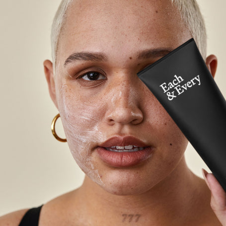 person with cleanser applied on face holding cleanser large image